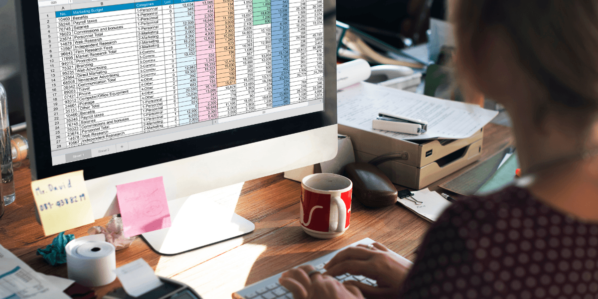 A woman focused on her computer screen, analyzing data in a spreadsheet
