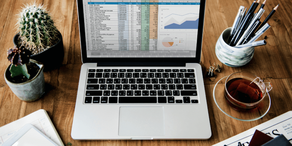 A person using Excel on a laptop, analyzing data to create a budget and track expenses for financial gain.